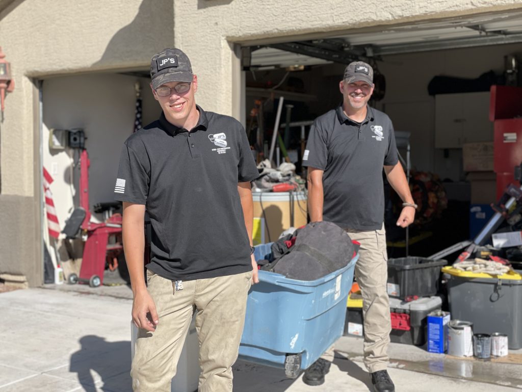Smiling professionals performing garage clean out services in the Las Vegas area